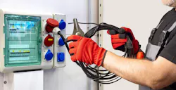 Electrician connects a high-power cable to an industrial socket panel, performing setup tasks related to electrical installation and temporary power distribution systems. Electrician connects a high-power cable to an industrial socket panel, performing setup tasks related to electrical installation and temporary power distribution systems.
