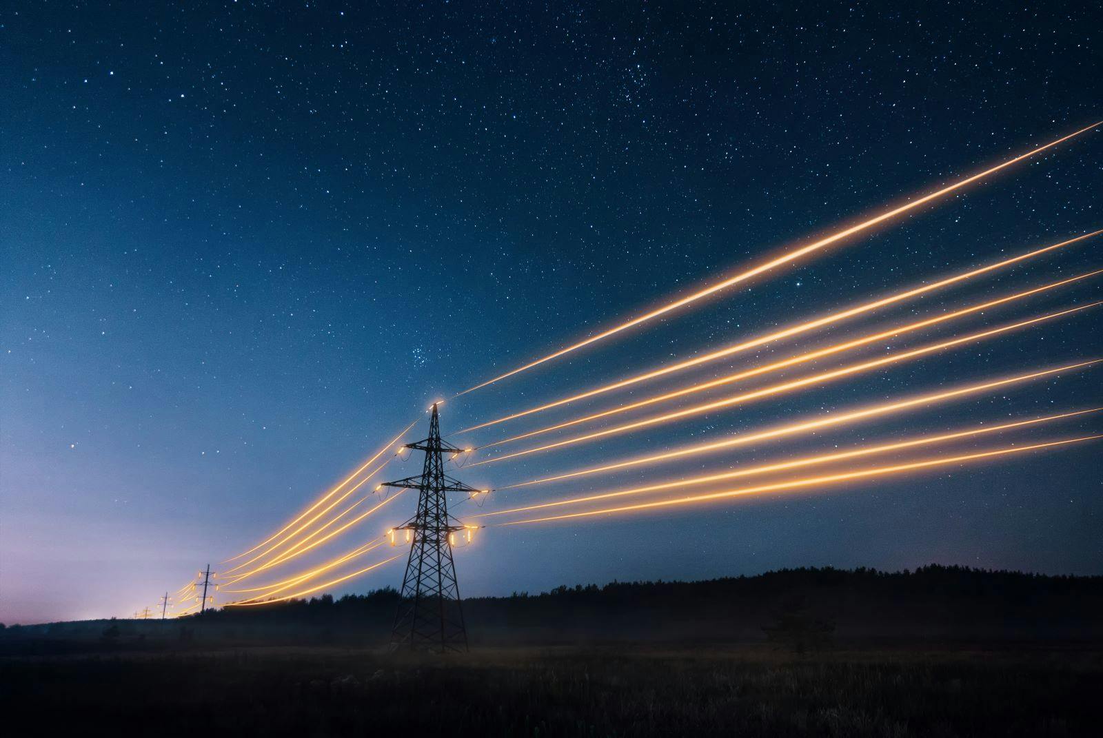 Electricity transmission towers with orange glowing wires the starry night sky