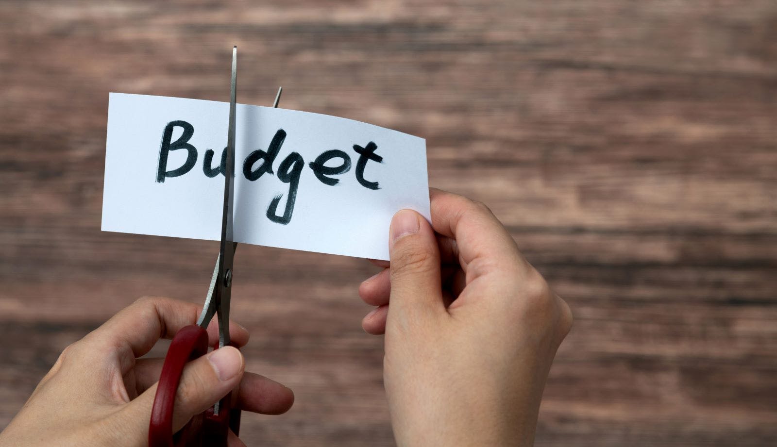 Scissors cutting word budget on paper