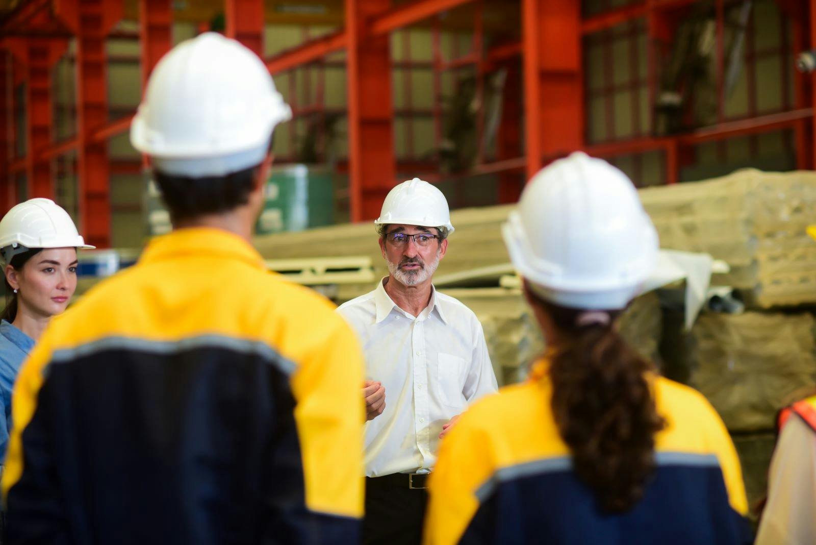manager engineer wearing safety hardhat is training industry worker