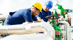 Two petrochemical workers inspecting pressure valves on a fuel tank Two petrochemical workers inspecting pressure valves on a fuel tank