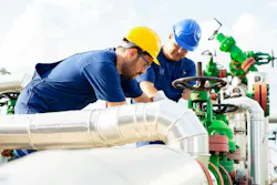 Two petrochemical workers inspecting pressure valves on a fuel tank Two petrochemical workers inspecting pressure valves on a fuel tank