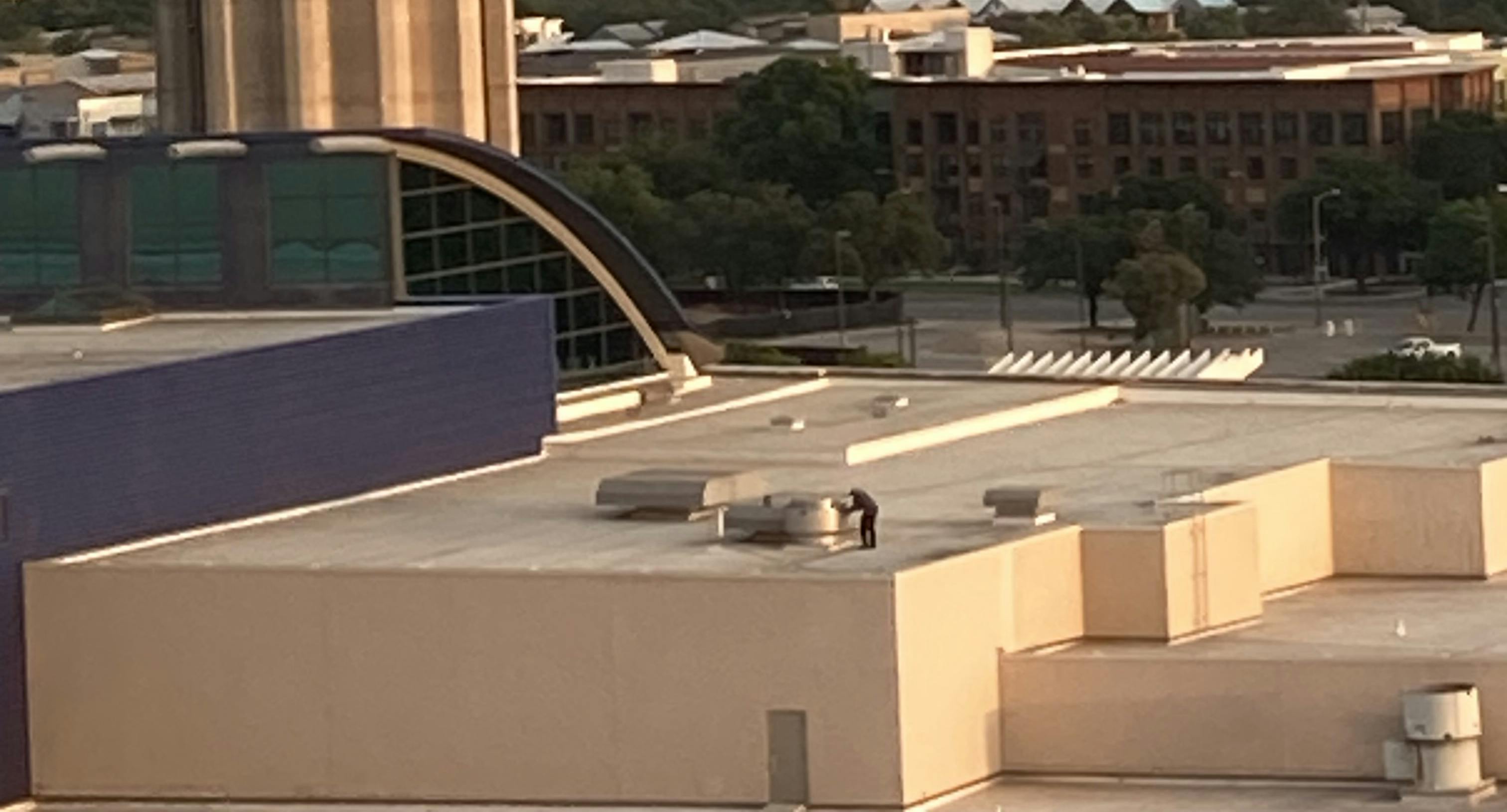 Though hard to see when not moving, a technician on the roof of San Antonio&rsquo;s convention center services some equipment in the field.