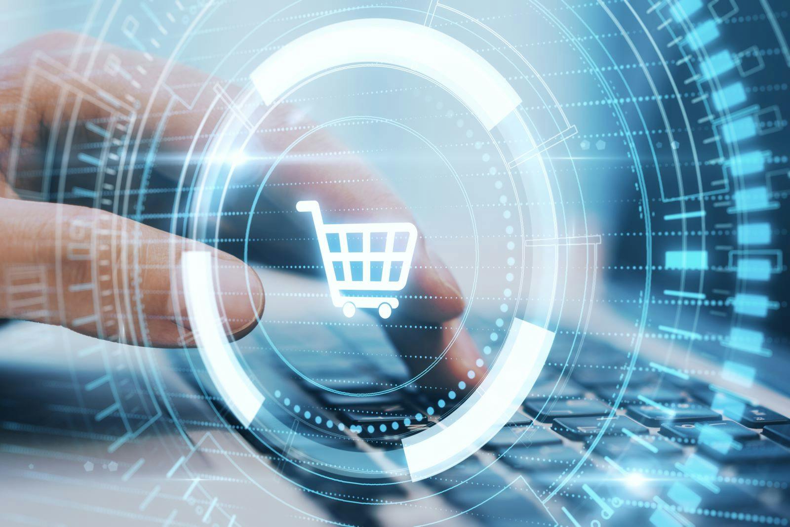 Close up hand typing on laptop keyboard with creative glowing blue cart hologram on dark background.