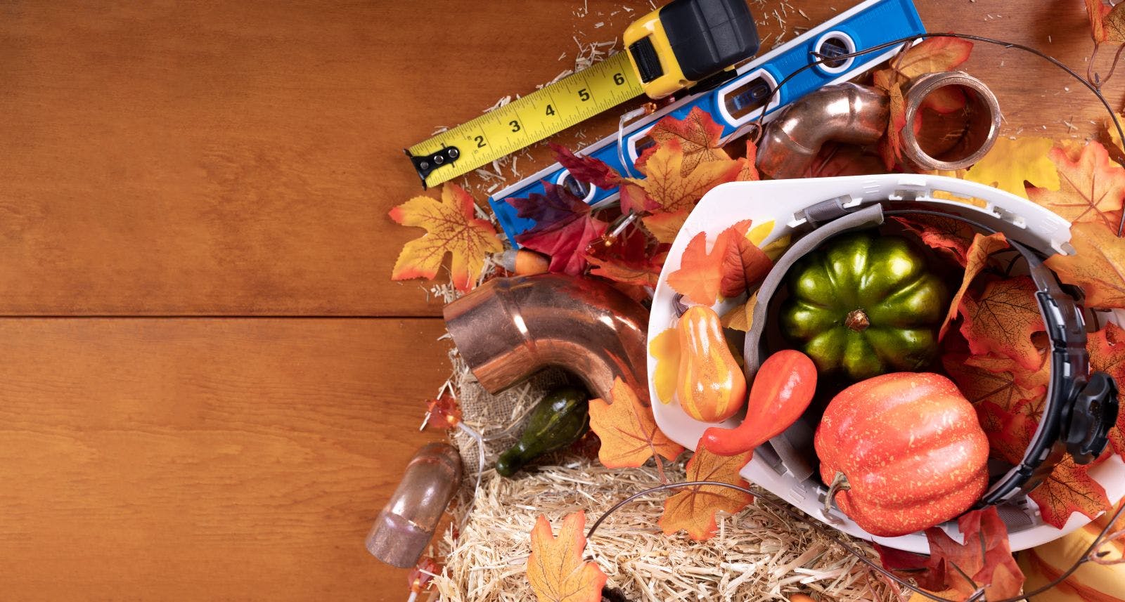 Happy Thanksgiving with construction tools, maple leaves and pumpkin on wood background. Autumn composition with copy space. Plumber Thanksgiving. Top view.