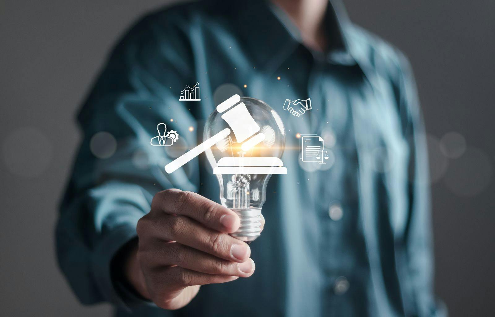 Businessman holding creative light bulb with symbol of justice and standards