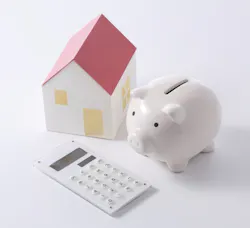 Calculator and piggy bank with a model of a house Calculator and piggy bank with a model of a house