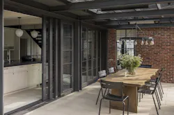 Moving the kitchen to the back of the house created an opportunity for indoor/outdoor living, with slide-and-stack window walls connecting the kitchen to a sheltered dining porch. Moving the kitchen to the back of the house created an opportunity for indoor/outdoor living, with slide-and-stack window walls connecting the kitchen to a sheltered dining porch.