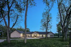 Twilight view of Texas custom home stone exterior with breezeway in the middle Twilight view of Texas custom home stone exterior with breezeway in the middle