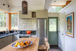 Shown is a contemporary kitchen with a green door and large windows Shown is a contemporary kitchen with a green door and large windows