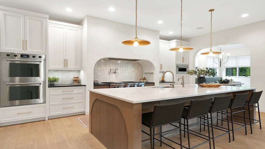 A large kitchen. with island and uniquely shaped vent hood