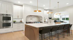 A large kitchen. with island and uniquely shaped vent hood A large kitchen. with island and uniquely shaped vent hood