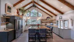An eat-in style kitchen with large A-frame windows looking out over trees An eat-in style kitchen with large A-frame windows looking out over trees