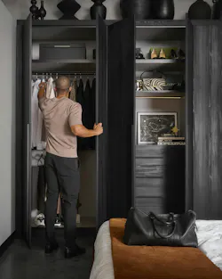 Designer Jerel Lake reaching into his new custom closet Designer Jerel Lake reaching into his new custom closet