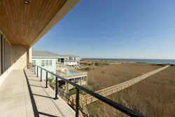 A long walkway connects the house to the beach. A long walkway connects the house to the beach.
