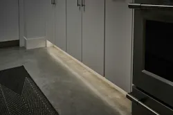 Toe kick area of a cabinet is illuminated by a white tape light Toe kick area of a cabinet is illuminated by a white tape light