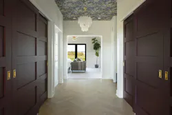 The primary suite closet is a deep eggplant-painted corridor, with a wallpapered ceiling and herringbone floors. The primary suite closet is a deep eggplant-painted corridor, with a wallpapered ceiling and herringbone floors.