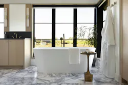 The purple veining of the honed marble flooring in the primary bath inspired the eggplant hue of the nearby closet doors (above). The purple veining of the honed marble flooring in the primary bath inspired the eggplant hue of the nearby closet doors (above).