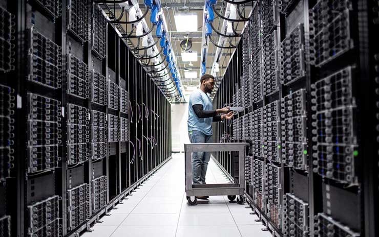 A technician works in rows of server racks in a Microsoft Azure cloud data center. (Image: Microsoft)
