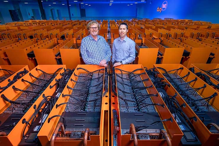 Dr. Matthew Lamont (left), DownUnder GeoSolutions (DUG) managing director, and Phil Schwan, DUG CTO, stand among the cooling tanks that make up the &ldquo;Bubba&rdquo; supercomputer at the Houston Skybox data center. (Credit: DownUnder GeoSolutions)