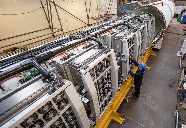 Engineers slide racks of Microsoft servers and associated cooling system infrastructure into Project Natick&rsquo;s Northern Isles datacenter at a Naval Group facility in Brest, France. The datacenter has about the same dimensions as a 40-foot long ISO shipping container seen on ships, trains and trucks. (Photo: Frank Betermin for Microsoft).