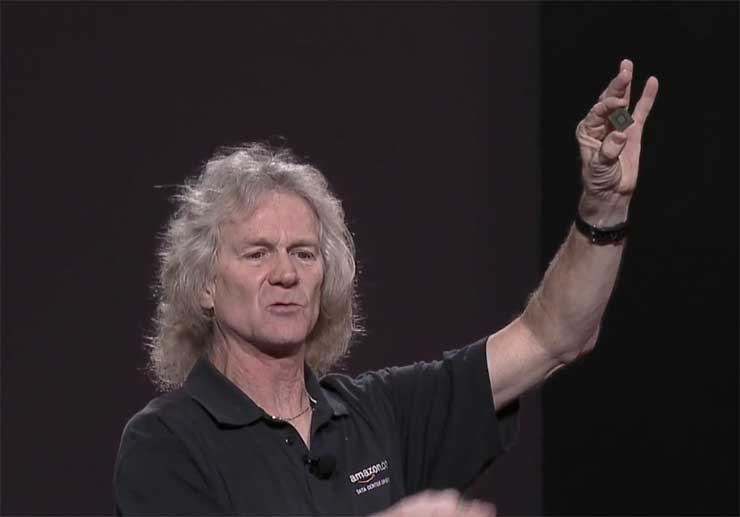 AWS Distinguished Engineer James Hamilton holds up a custom ASIC created by Amazon to power its networking gear. (Screen shot via Amazon video)