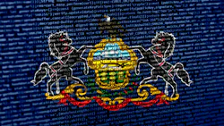 The flag of Pennsylvania here floats over over digital code, highlighting the concepts of AI and and digital infrastructure innovation within the state, which has become a burgeoning hot spot for hyperscale data center development. The flag of Pennsylvania here floats over over digital code, highlighting the concepts of AI and and digital infrastructure innovation within the state, which has become a burgeoning hot spot for hyperscale data center development.