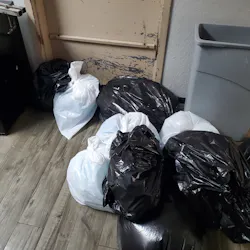 Note full trash bags blocking employees’ exit. This represents a potential fire safety issue. Note full trash bags blocking employees’ exit. This represents a potential fire safety issue.
