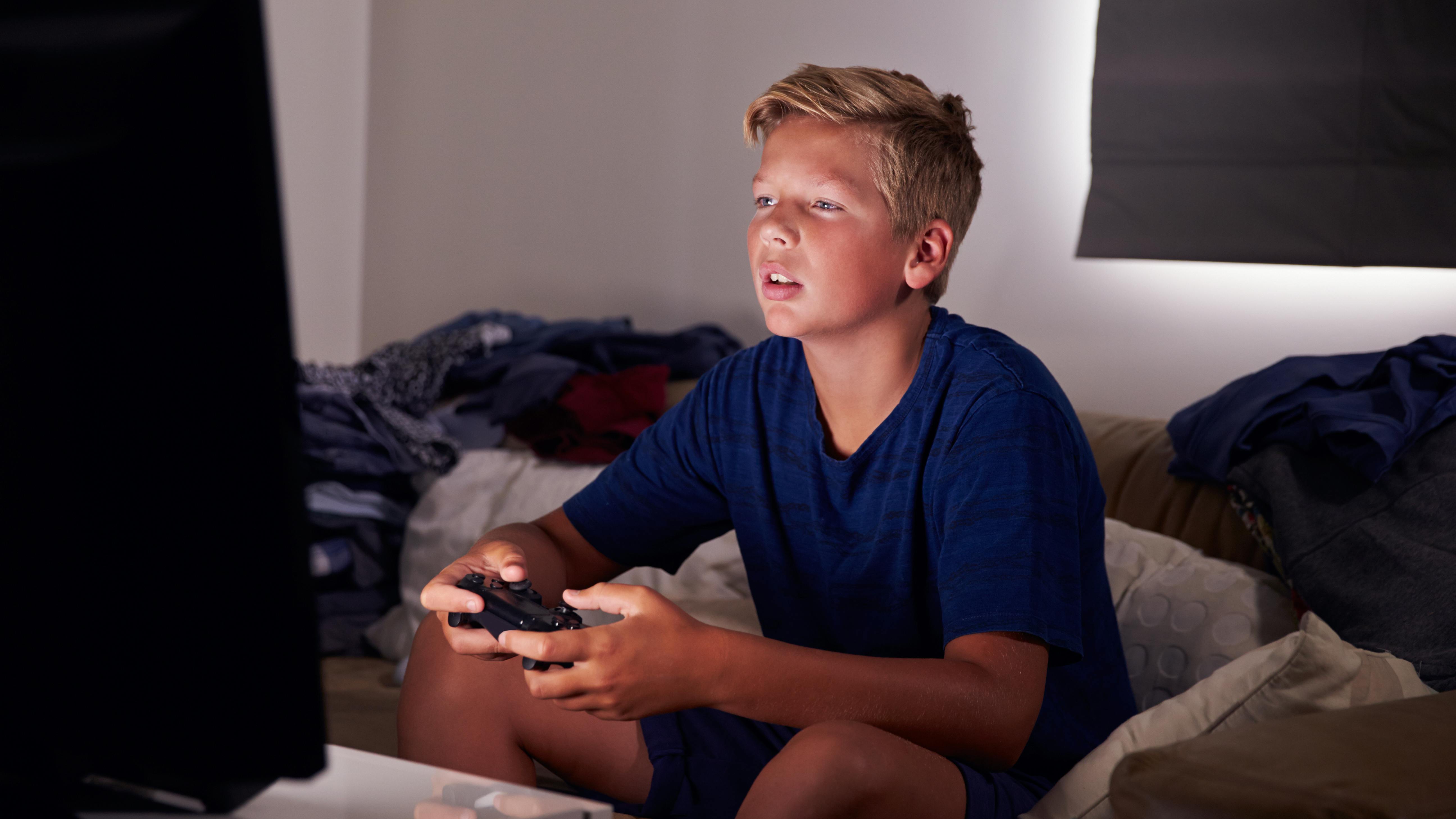 Teen boy staring at screen playing a video game