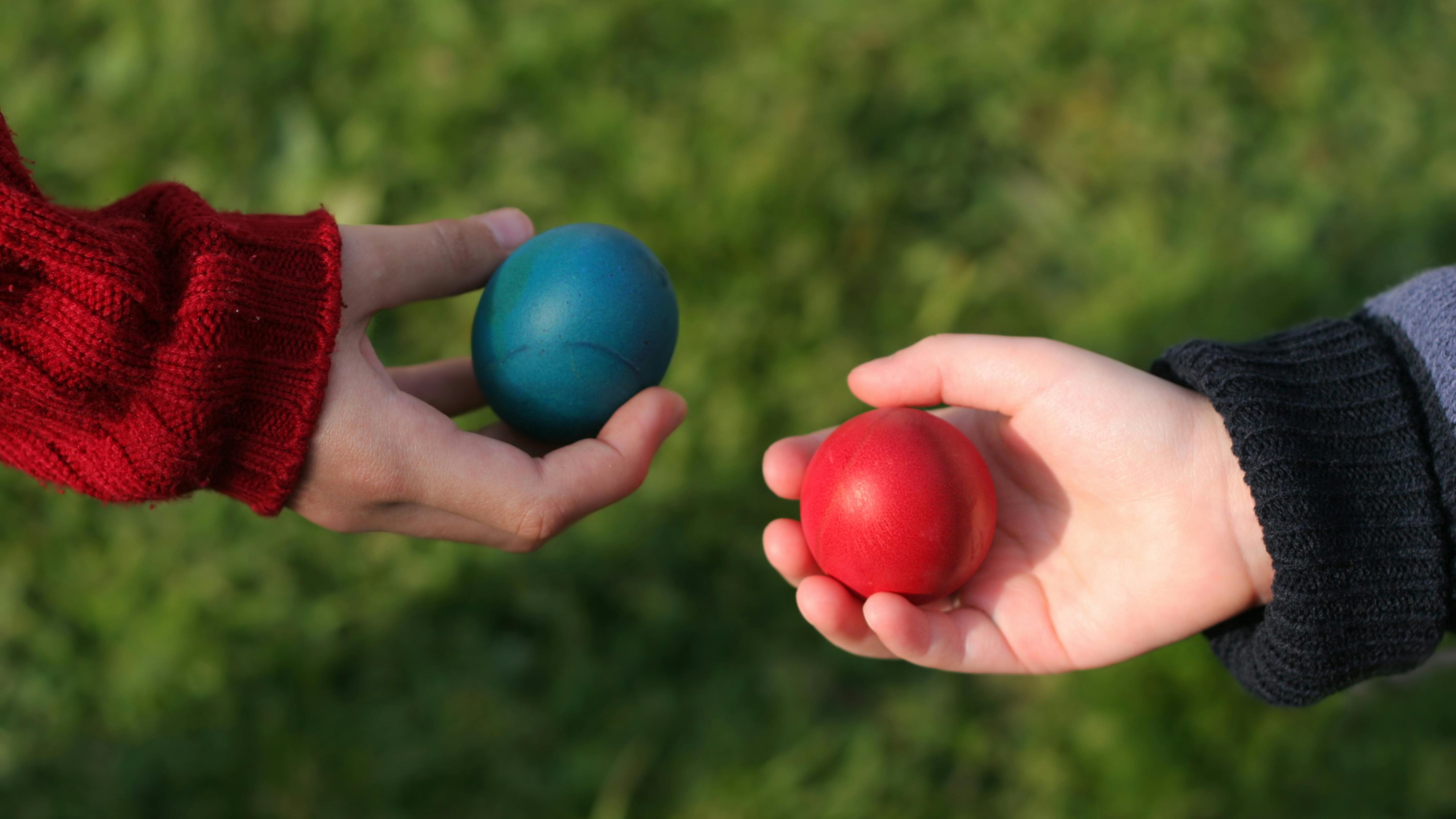 Two outstretched hands, each holding a ball, as if in trade