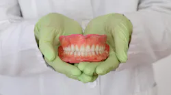 gloved hands holding a model of teeth gloved hands holding a model of teeth