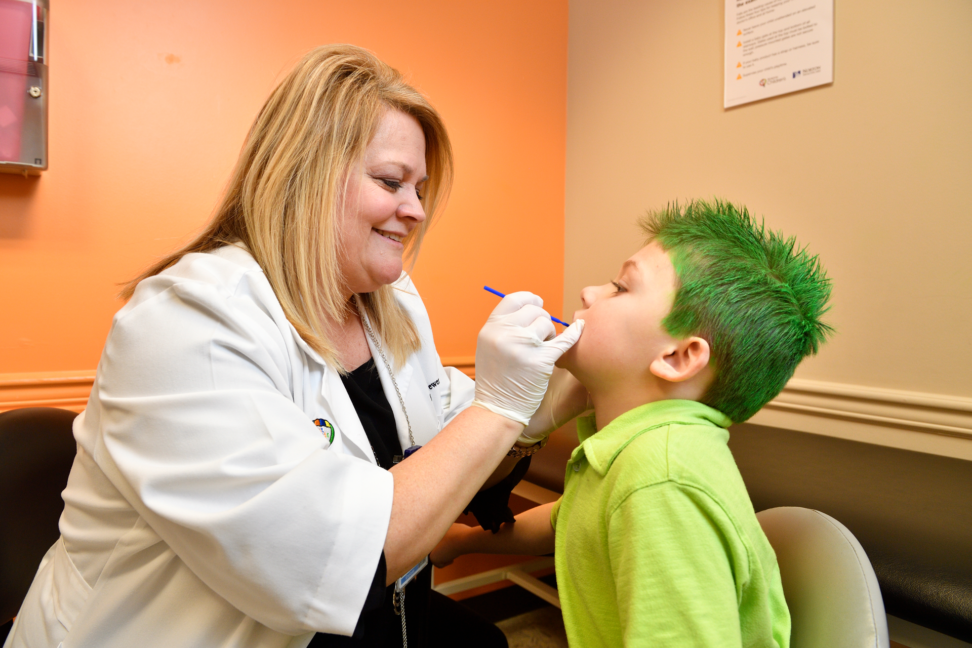 Dawn Brewer, APRN, applies fluoride varnish at a wellness check.