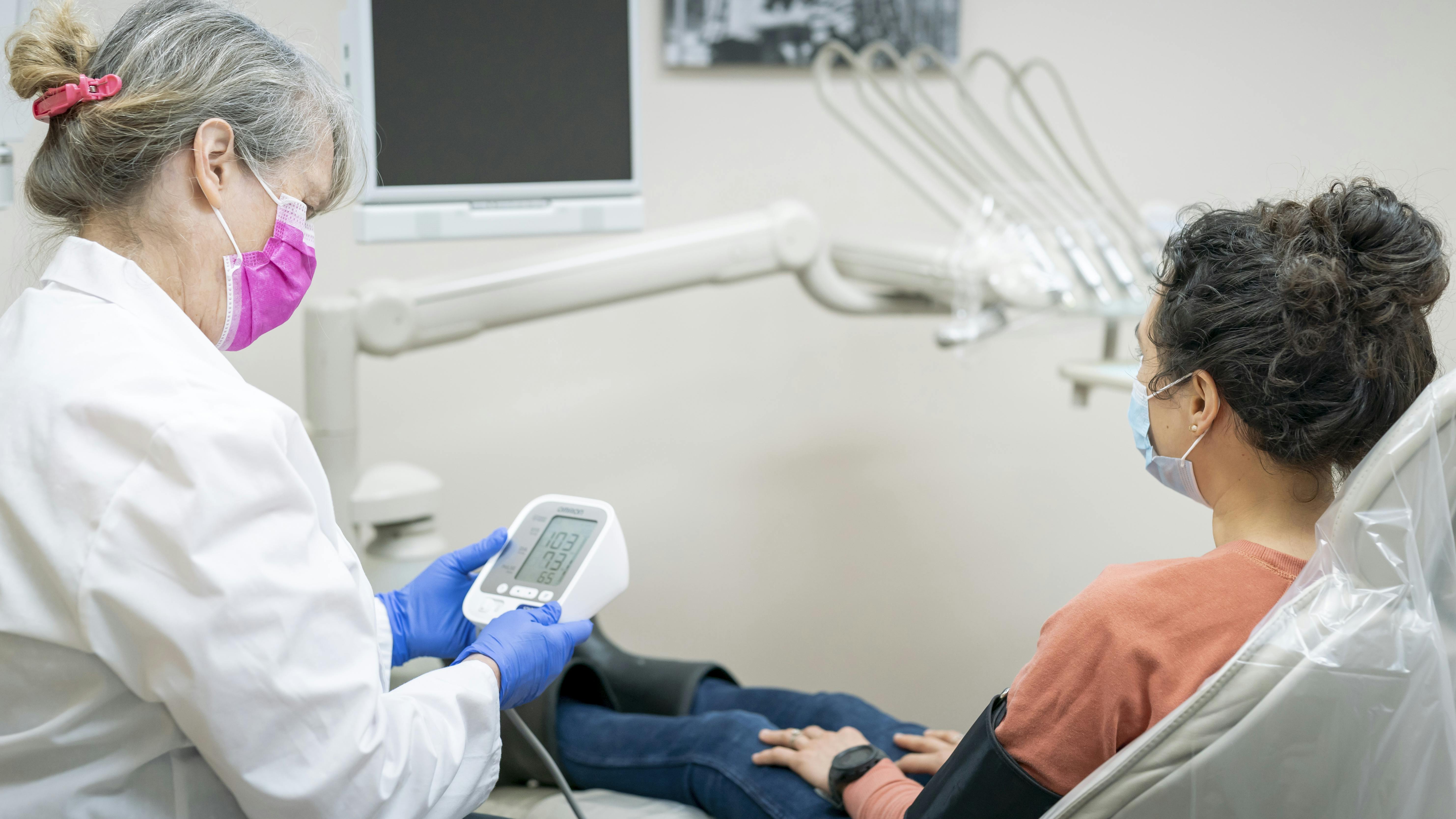 woman getting her blood pressure taken at the dentist's office