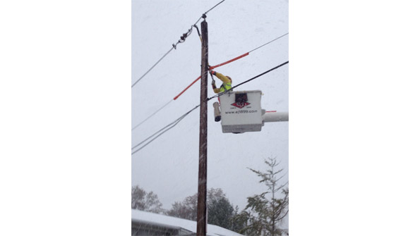 A lineman from EJ Electric Installation Co Long Island NY works to restore power in a neighborhood hit by Hurricane Sandy