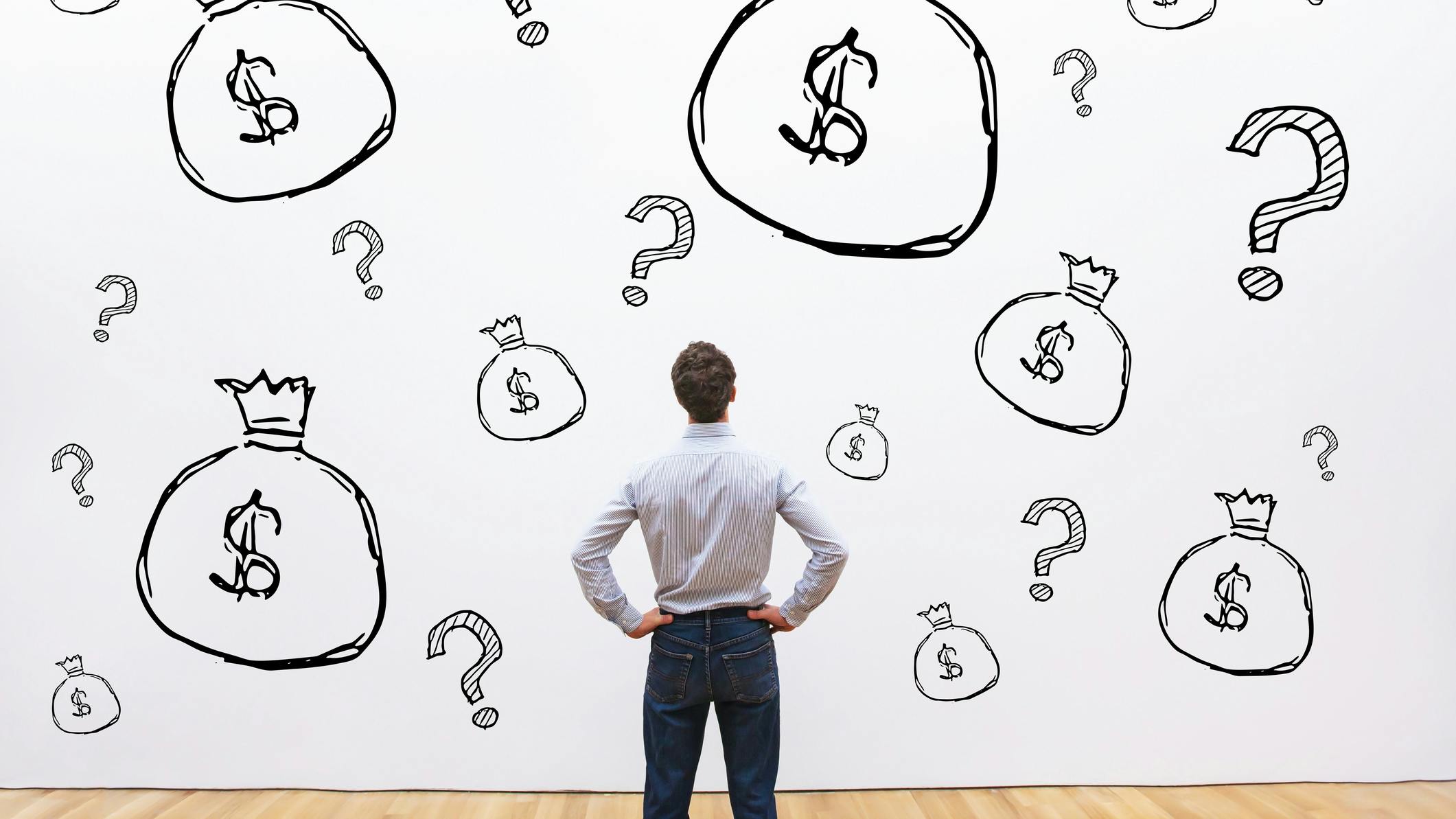 Man staring at wall with hand-drawn question marks and money bags on it