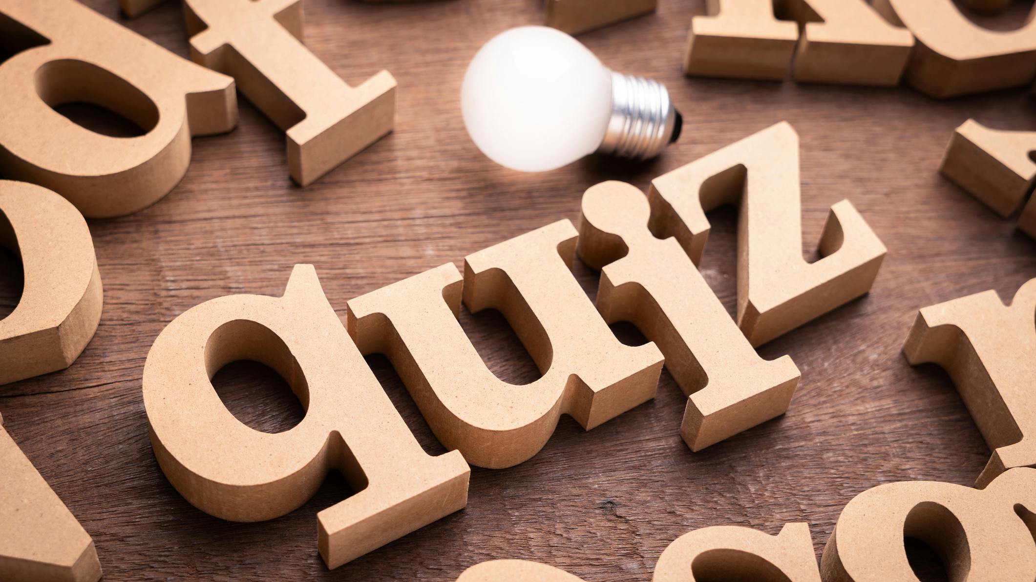 Wooden blocks that spell out 'quiz' with a light bulb above it