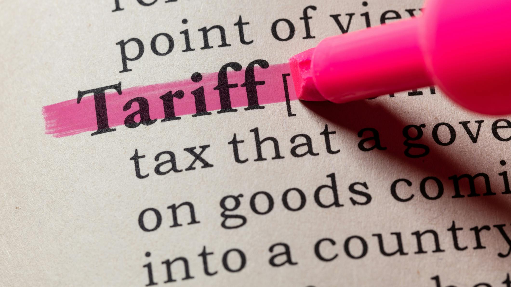 A close up of the dictionary definition for 'tariff.' A pink highlighter has highlighted the word 'tariff'.