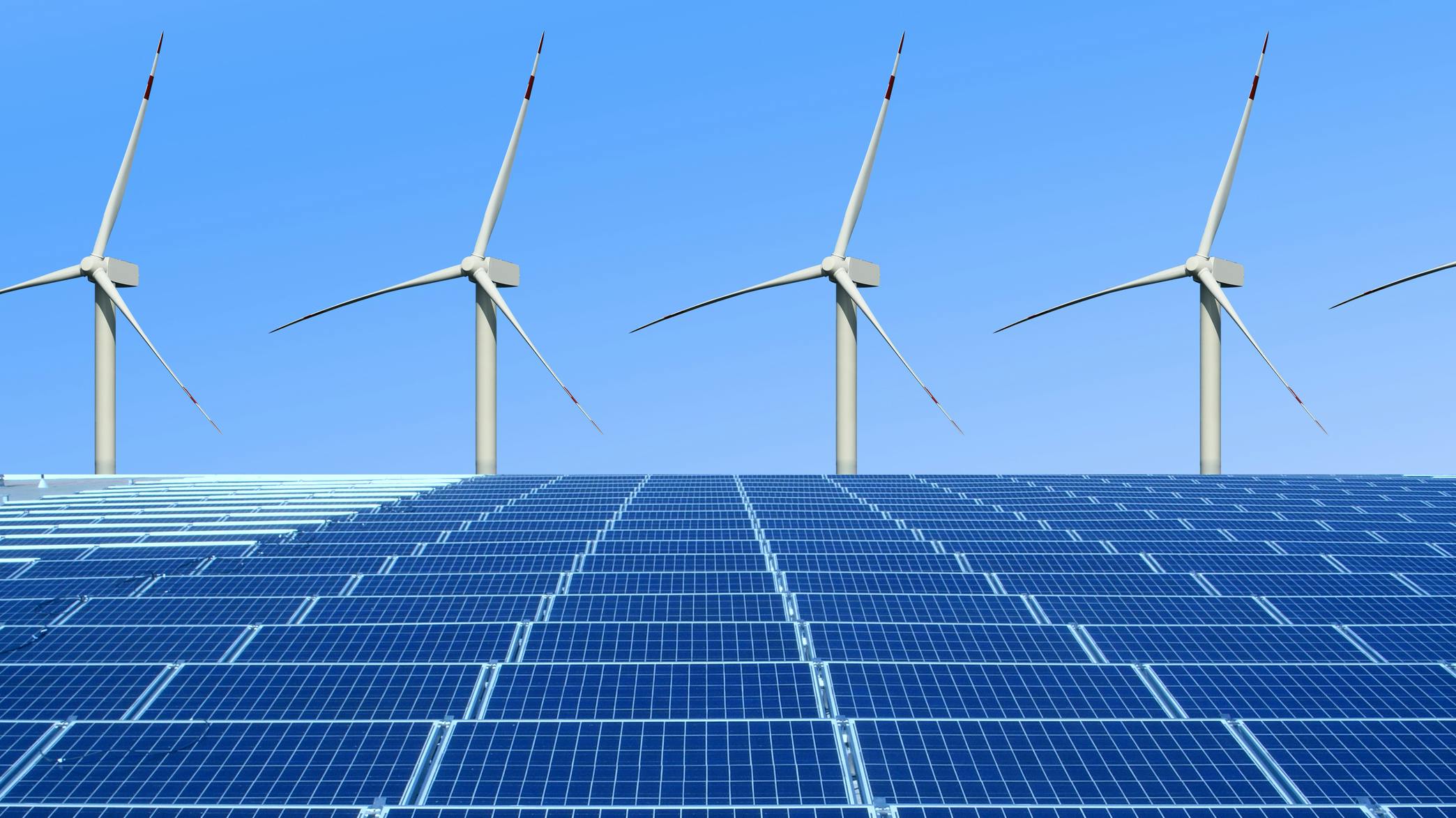 A solar array with large wind turbines behind it