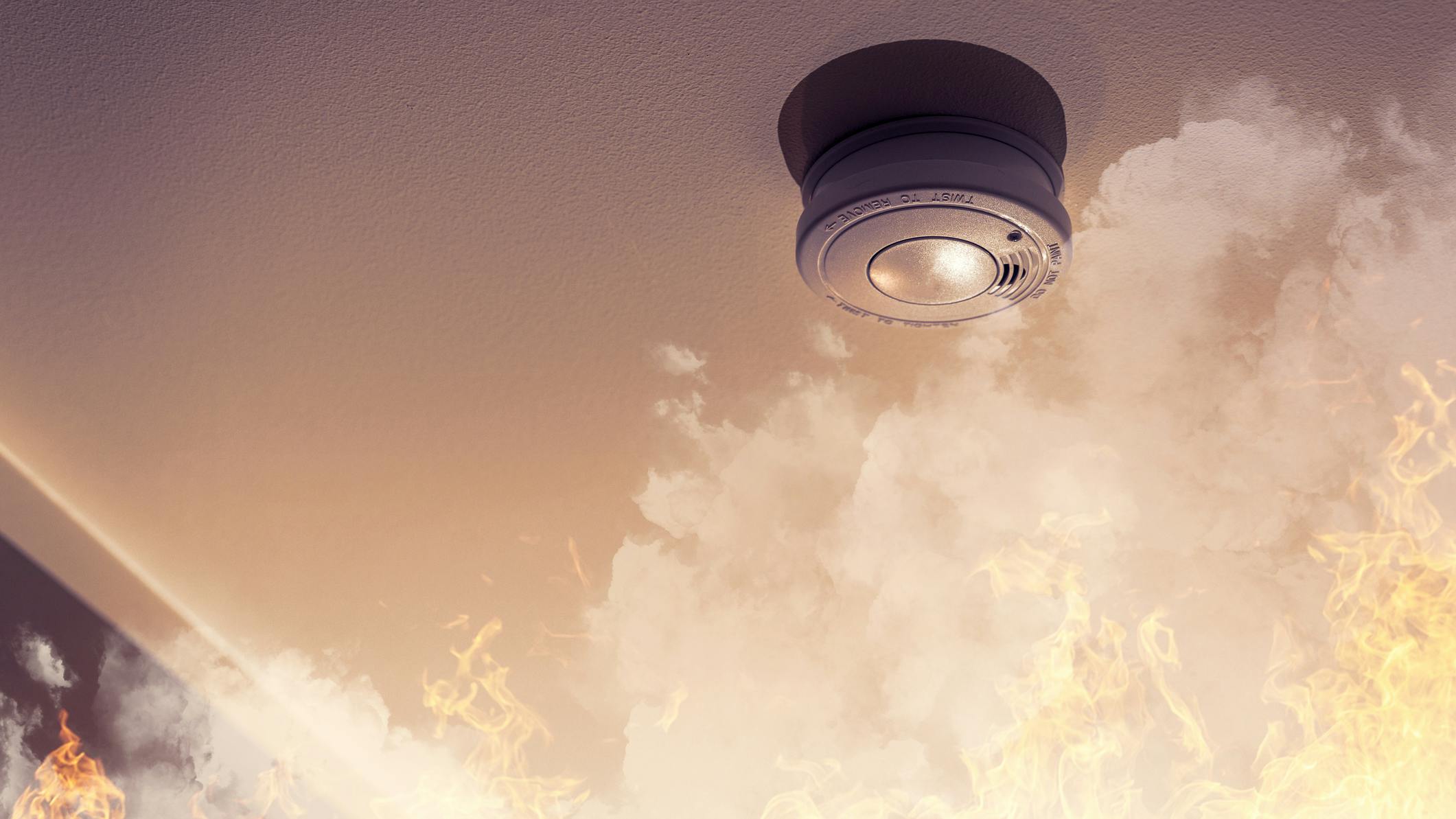 Home safety - smoke detector on ceiling detecting house fire