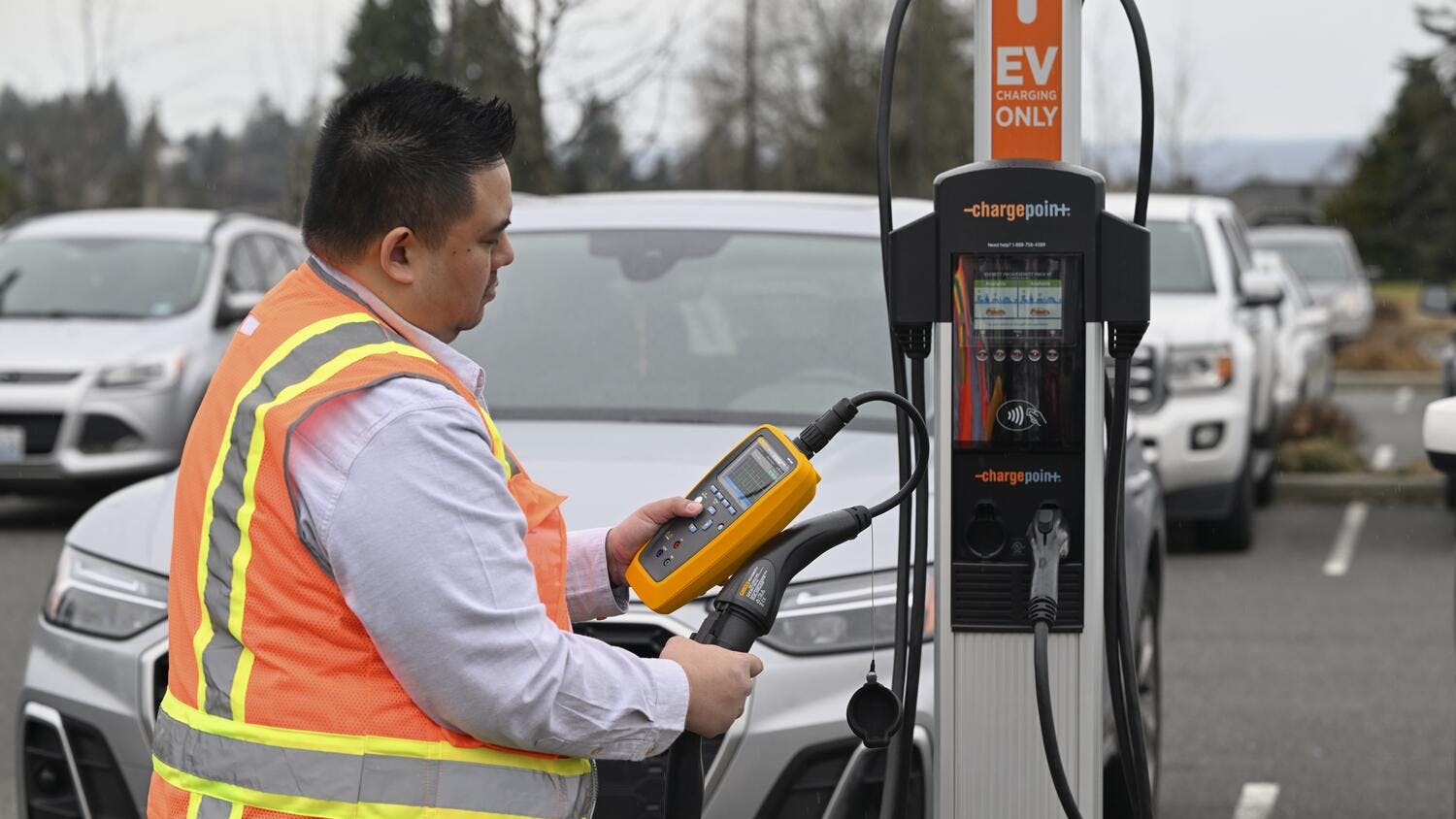 Employee performing maintenance work on an EV charging station.