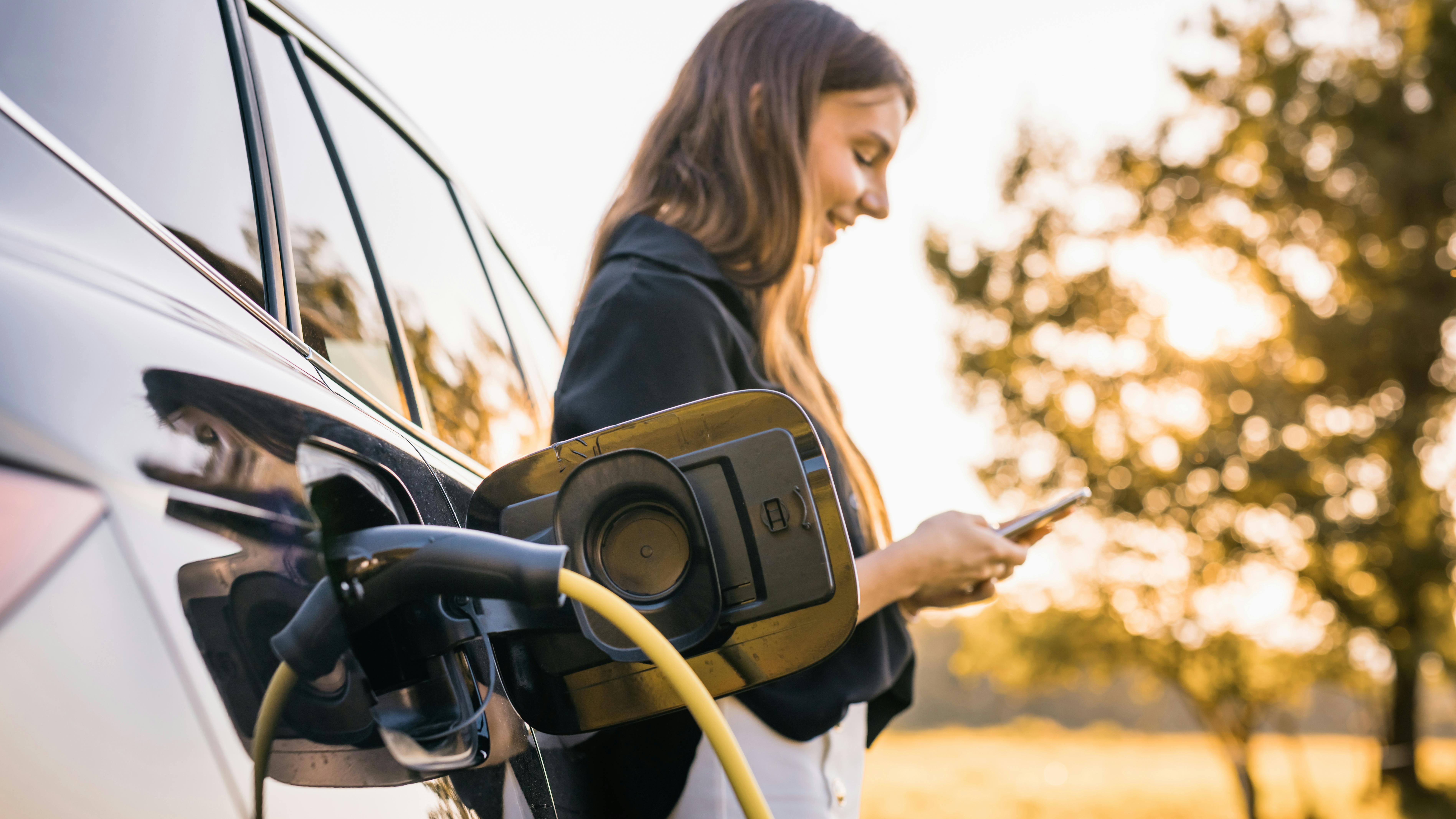 woman charging ev outdoors