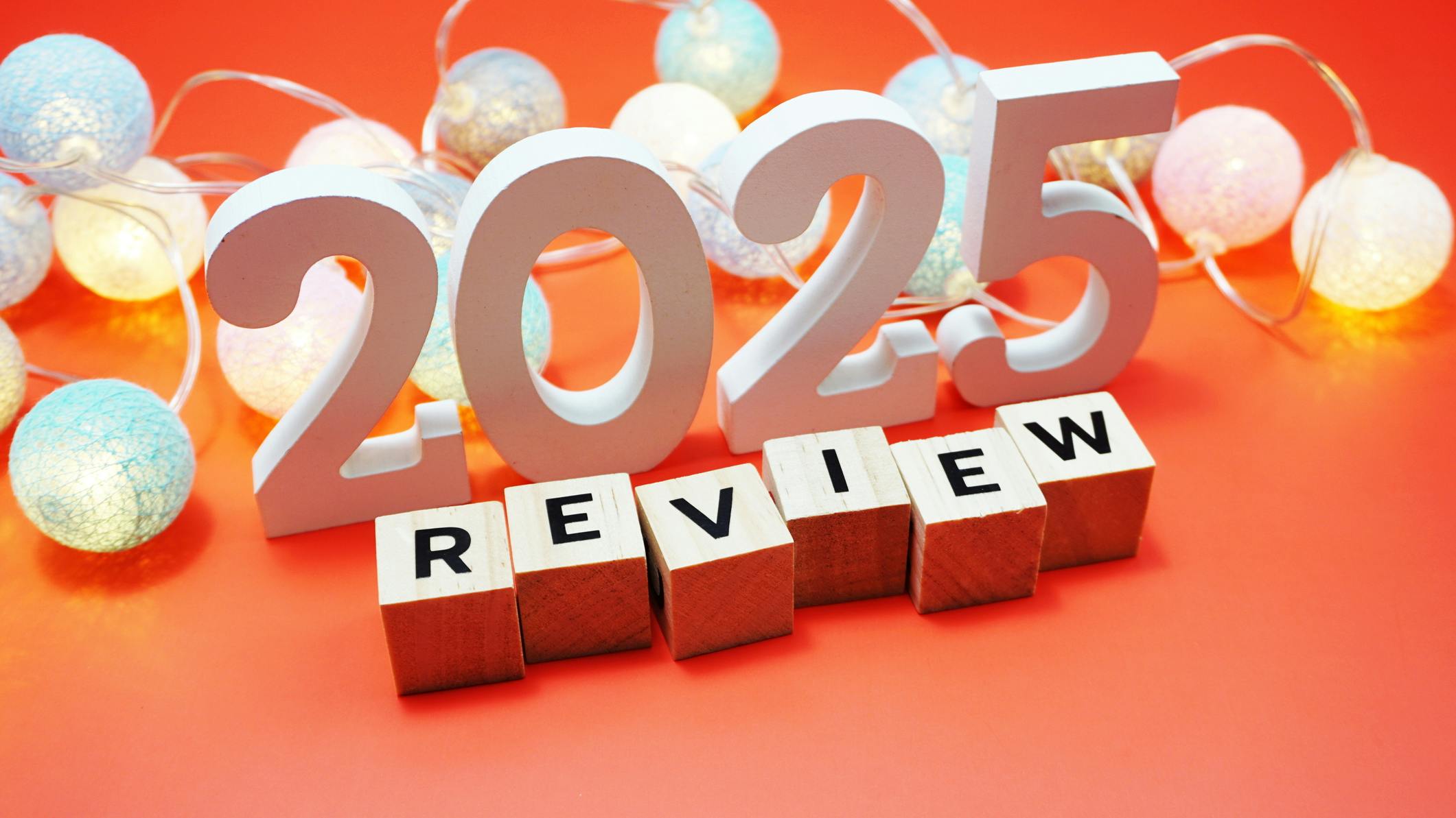 Review 2025 alphabet letters with space copy on red background. Review 2025 alphabet letters and LED cotton balls decoration with space copy on red background