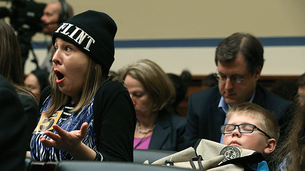 Desiree Duell L reacts to testimony from Michigan Gov Rick Snyder while her 10yearold son David Henderson sits nearby during a House Oversight and Government Reform Committee hearing about the Flint Mich water crisis on Capitol Hill March 17 in Washington DC The committee was examining how lead ended up in the public drinking water in Flint