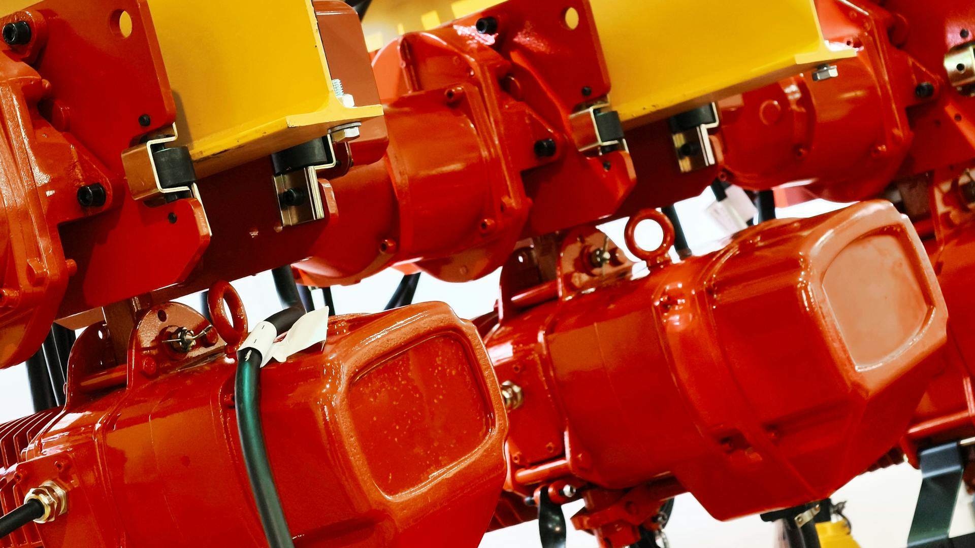 Red wire rope hoist machinery ready for lifting operations in a modern industrial facility