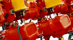 Red wire rope hoist machinery ready for lifting operations in a modern industrial facility Red wire rope hoist machinery ready for lifting operations in a modern industrial facility
