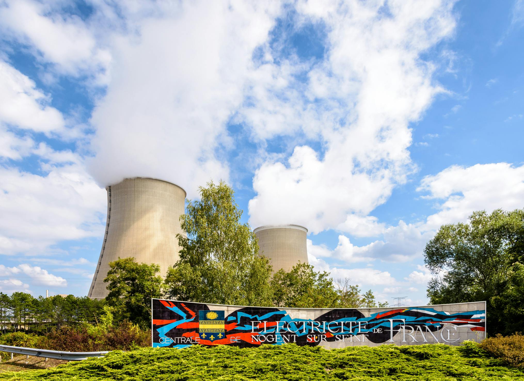 Welcome sign and cooling towers of the EDF nuclear power plant of Nogent-sur-Seine, France. Nogent-sur-Seine, France. Image credit ID 196326600 &copy; Olrat | Dreamstime.com