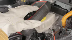 A technician wearing proper PPE tests underhood components. A technician wearing proper PPE tests underhood components.