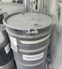 This drum of liquid solvent waste is properly labeled and grounded, as shown by the red clamp at the rear. This drum of liquid solvent waste is properly labeled and grounded, as shown by the red clamp at the rear.