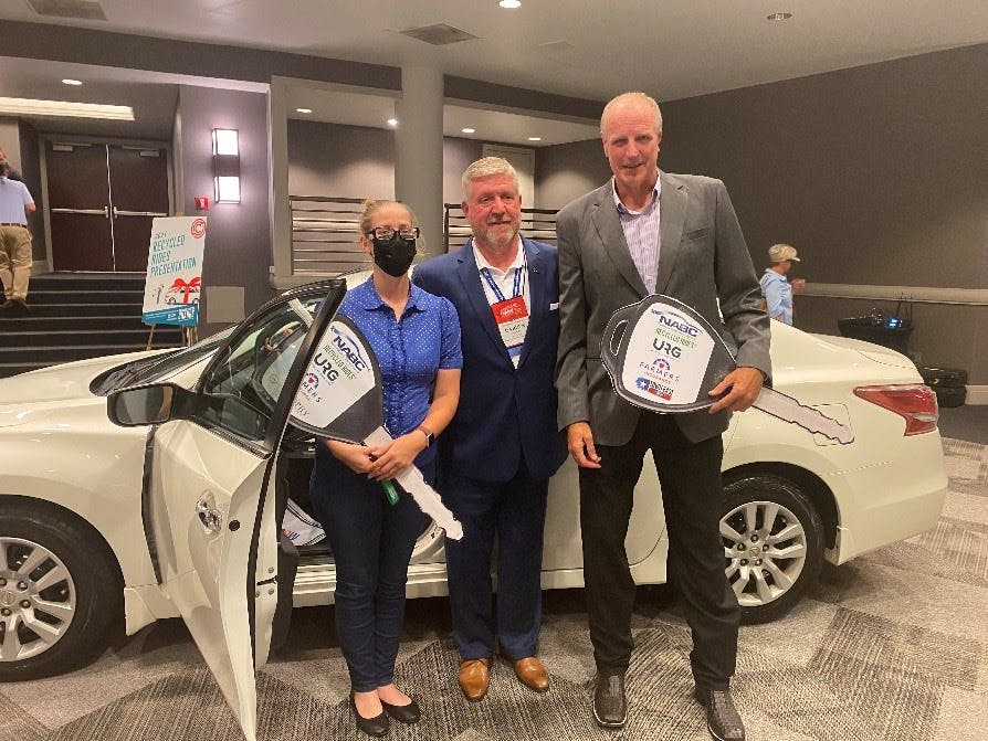 Randi Ruthart-Garrison is presented a 2014 Ford Fusion, refurbished by Town East Ford, by NABC Immediate Past Chair Darren Huggins (c.) and Don Porter, CEO of URG.