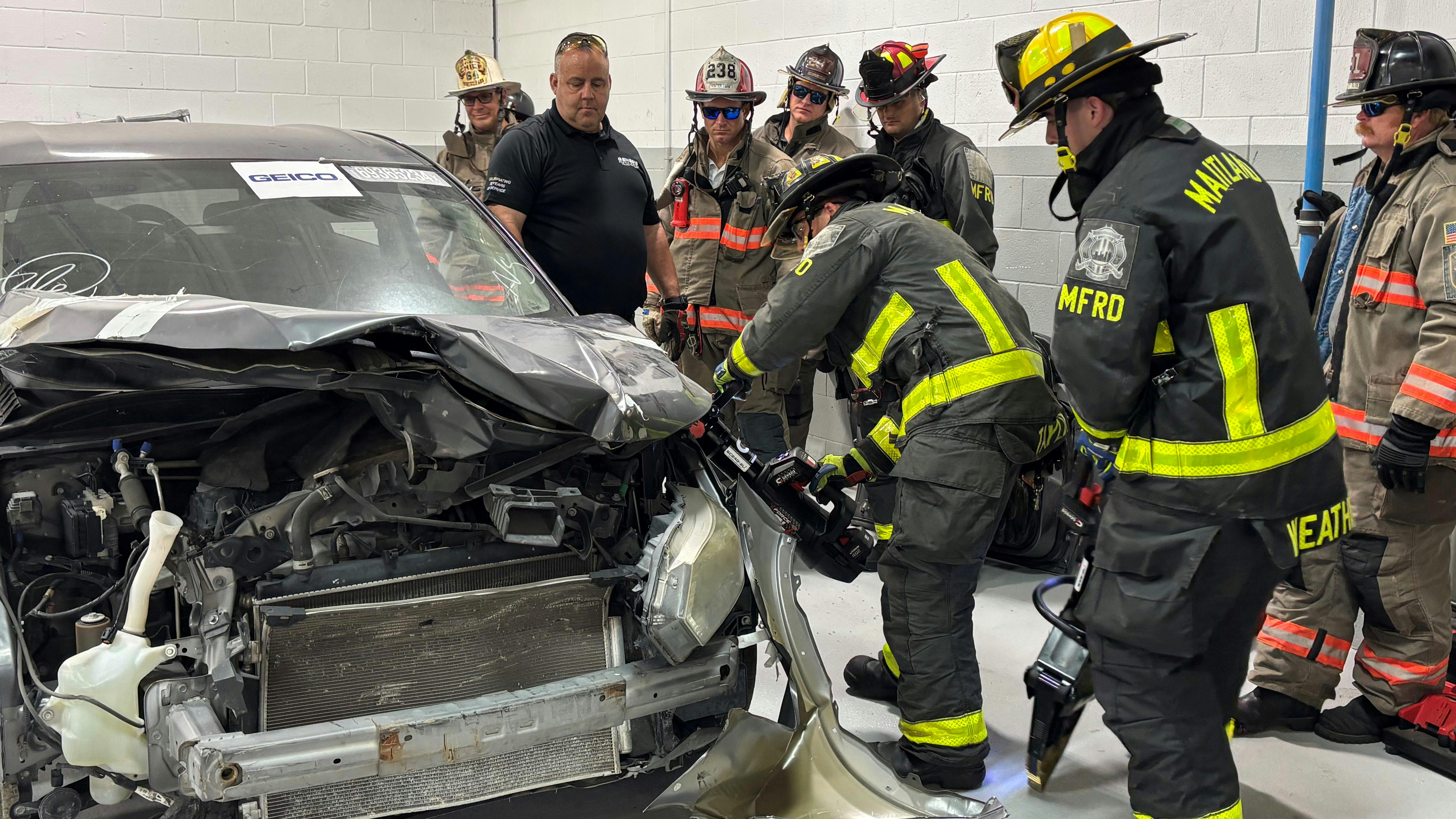 Members of the Seminole County, Maitland, and Winter Park Fire Departments participate in hands-on training as part of the National Auto Body Council on September 4 in Orlando, Florida.
